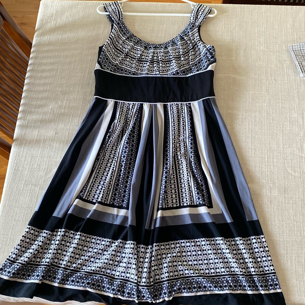 Women’s midi dress, shapes and lines, colors are black, grey, and cream.
